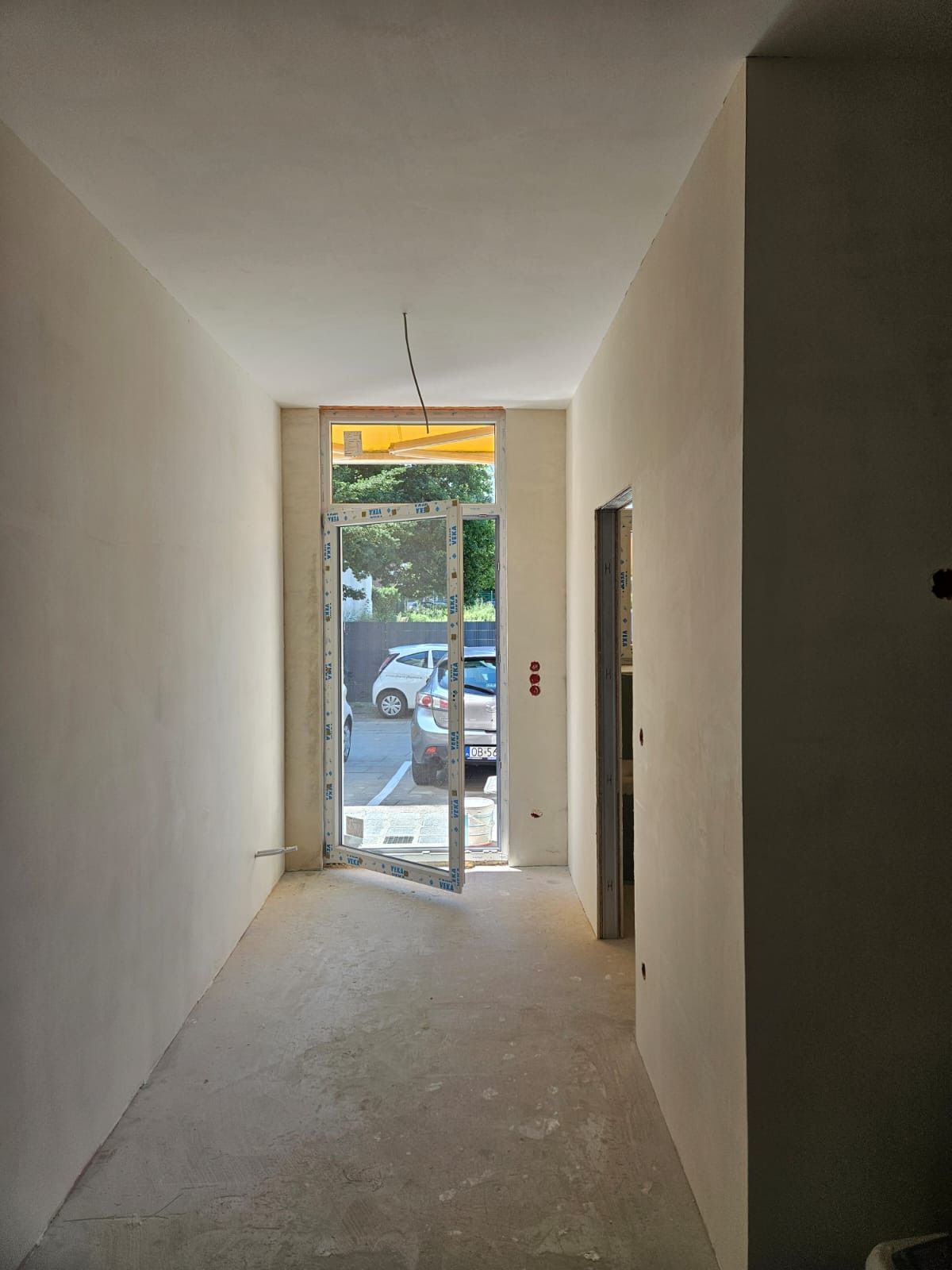 Neuer Flur im Rohbau mit Blick zur Straße